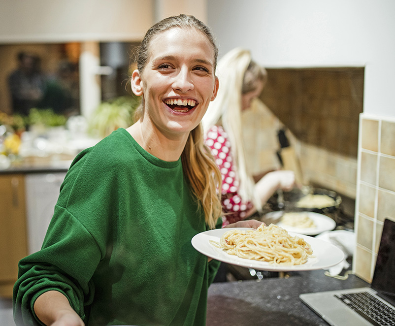 Photo of a young female serving up a spaghetti dinner